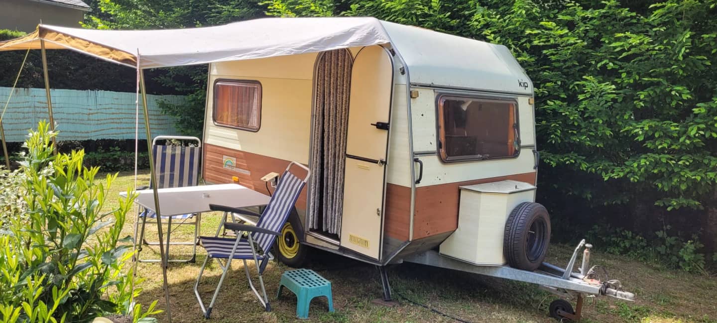 De KIP-caravan met luifel en tuinstoelen