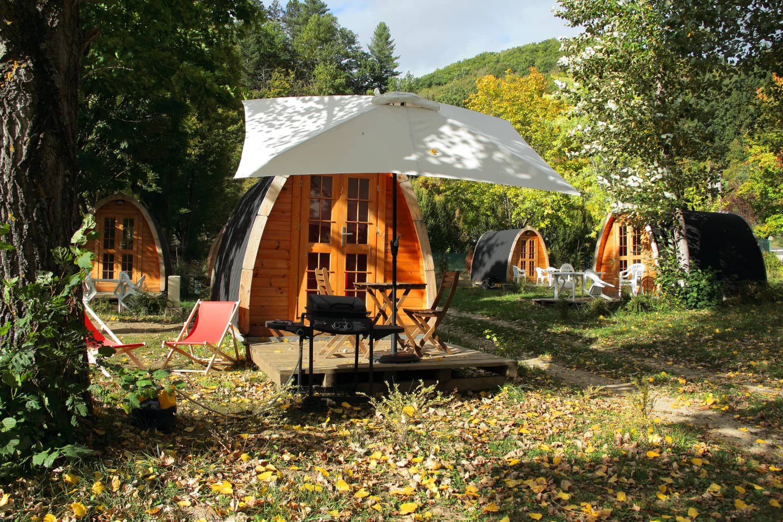 De PODs met parasol en ligstoelen in het herfstlicht