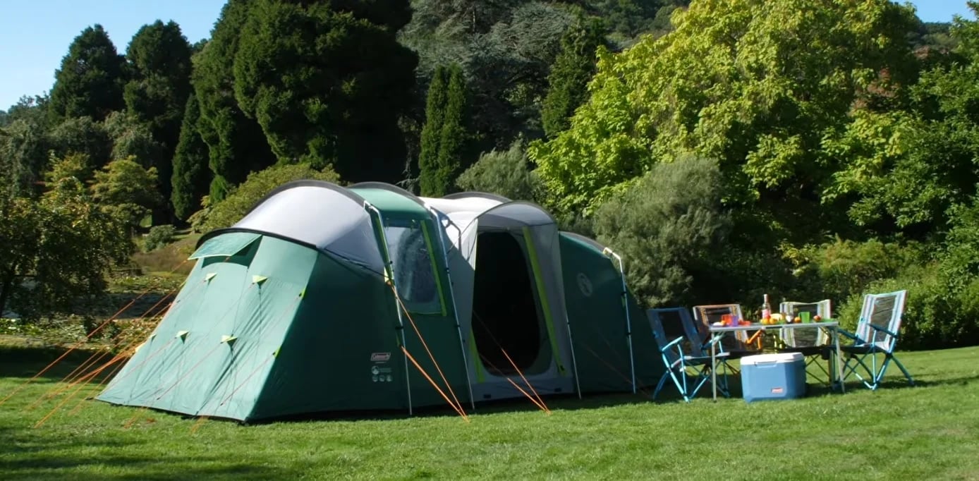De ingerichte tunneltent voor zes personen, met tuinset op het gras